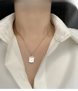 Close-up of square titanium pendant with 'Take your memory' engraving on a thin chain