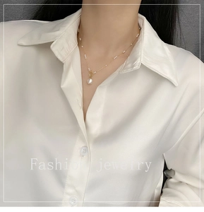 Detailed view of baroque pearl necklace with gold chain and T-bar clasp on model