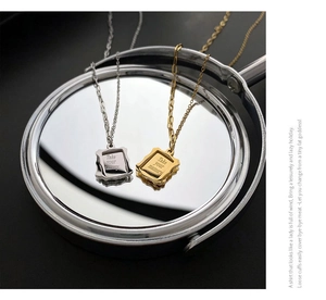 Detail of vintage square frame pendant with Take Your Memory engraving on O-chain