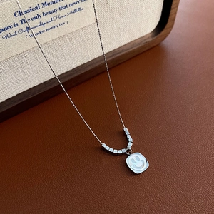 Titanium steel smiley face necklace with square pendant on brown leather texture