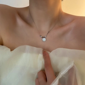 Minimalist shell smile pendant necklace on model showing refined silver-tone design