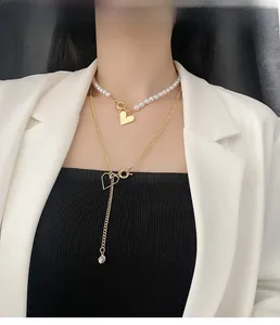 Détail d'un collier doré multicouche avec perles, cœurs et pendentif en forme de Y élégant