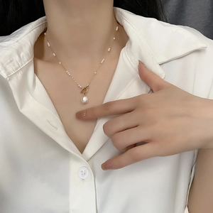 Elegant gold choker featuring a baroque pearl pendant and delicate small pearl accents