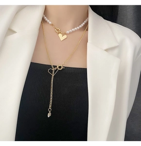 Détail du collier de perles à cœur superposé avec glands dorés et strass sur mannequin