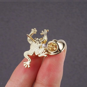 Broche grenouille dorée avec perle montrant l'épingle et le fermoir papillon au dos