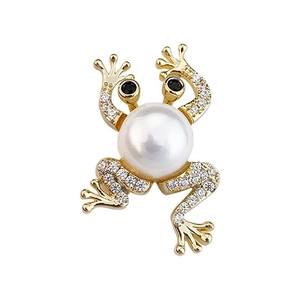 Broche grenouille dorée avec grande perle blanche et cristaux brillants sur fond blanc