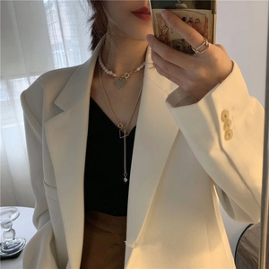 Collier à perles multicouche avec pendentif cœur sur mannequin en costume blanc