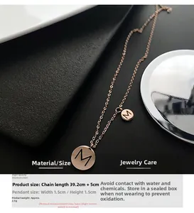 Vue détaillée du collier M en or rose avec pendentif de 1,5cm sur coussin de cuir noir