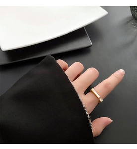 Detail of gold-plated shell and zircon open ring worn by a model in a modern style