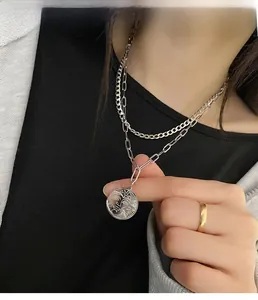 Detail of layered titanium steel necklace with personified sun moon pendant on model