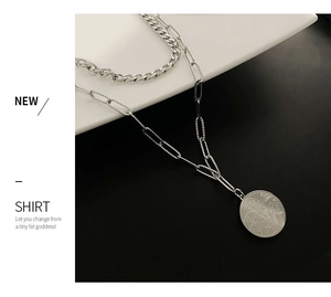 Detail of silver double layer necklace with portrait coin pendant on cuban chain