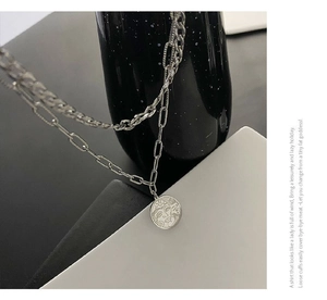 Macro view of double-layered titanium steel necklace with sun goddess face pendant