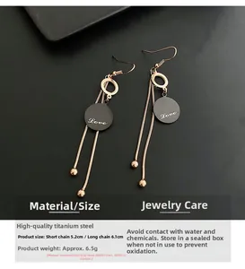Detailed view of rose gold titanium leaf tassel earrings with love engraving