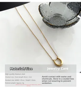 Detailed view of golden U-shaped horseshoe necklace with chain specs and jewelry care guide