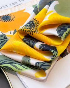 Gros plan sur l'imprimé tournesol jaune éclatant d'un foulard en soie de luxe soyeux