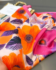 Détail d'un foulard en satin aux imprimés floraux vifs en orange et tons violets