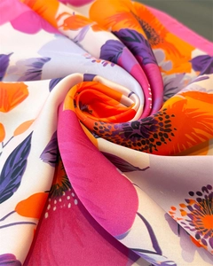 Vue macro d'un foulard en satin soyeux avec fleurs roses vives et plis élégants drapés