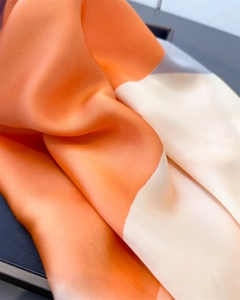 Detail von seidenähnlichem Stoff mit orangefarbenem und grauem Farbmuster-Design