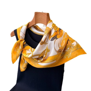 Elegant chain print silk satin square scarf in golden yellow on a minimalist wood hanger