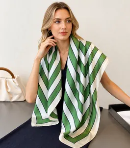 Detail of silk-like green and white geometric striped scarf on a wooden hanger