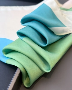 Detailaufnahme des Seidenschals mit Farblock-Design und elegantem Satin-Glanz-Effekt