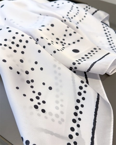 Detail of silk-like satin fabric showing geometric dots and soft drape texture