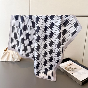 Detail of silk-like scarf with black and white geometric pattern on a minimal rack
