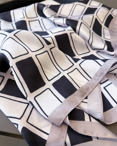Detail of geometric grid silk scarf showing smooth texture and elegant drapes of the fabric