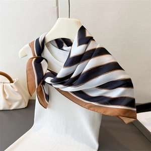 Elegant geometric stripe silk square scarf in black and beige styled on a knit vest