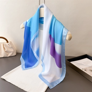 Eleganter Seidenschal mit modernem Farbverlauf in Blau und Violett auf weißem Strick