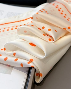 Macro shot of geometric orange polka dot silk scarf with elegant satin luster and texture