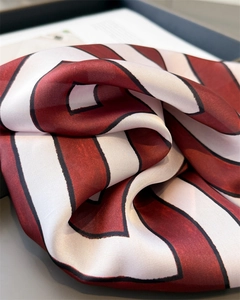 Close-up of geometric striped silk-like scarf showing smooth texture and drape
