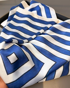 Close-up of geometric blue and white silk scarf texture with modern striped pattern