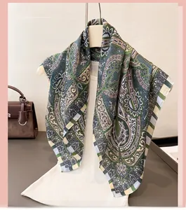 Detail of green paisley patterned silk scarf tied elegantly on a white mannequin