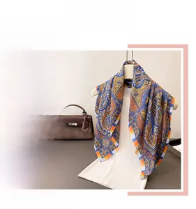 Close-up of elegant blue paisley silk scarf with intricate patterns and soft drape