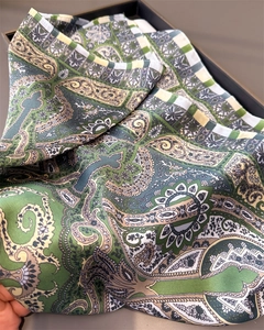 Detail of green silk scarf with intricate paisley pattern and glossy texture finish