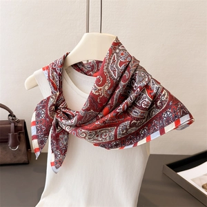 Detail of red and white paisley silk scarf tied on a white top for styling