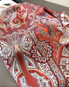 Macro shot of paisley printed silk scarf showing fine floral texture and satin finish