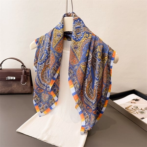 Classic paisley pattern square silk scarf in royal blue and orange on a white top