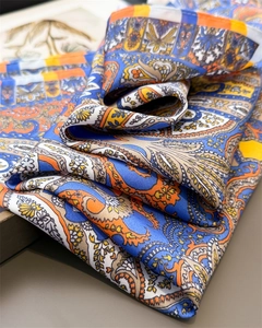 Detailed close-up of blue and orange paisley silk scarf with bohemian geometric patterns