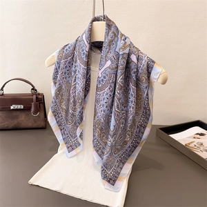 Elegant paisley print silk square scarf in soft pink, blue and purple on a white hanger