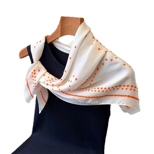 Polka dot silk-like satin square scarf in orange and white tied on a black top