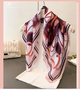 Detail of silk-feel scarf with vintage chain print and tassels on a fashion mannequin