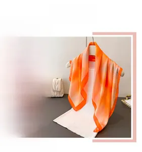 Detail of vibrant orange silk scarf with watercolor floral print and elegant texture