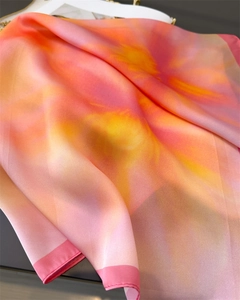 Close-up of pink and orange gradient silk scarf with fine rolled edges and satin sheen