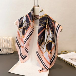 Elegant silk scarf with pink and black chain print shown on a mannequin bust