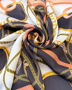 Detail of silk-like satin scarf featuring vintage gold chain and orange leather patterns