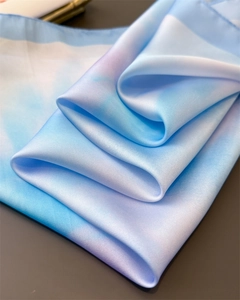 Close-up of silky blue and white gradient fabric showing luxurious texture and sheen