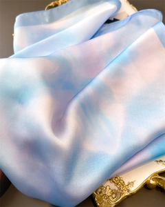 Close-up of silk scarf with blue and purple gradient on a gold vintage tray