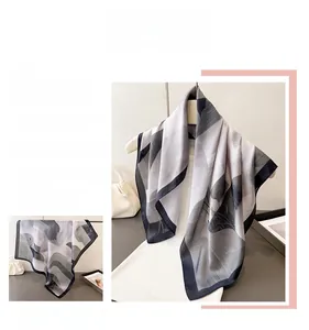 Detail of elegant gradient leaf pattern on a semi-transparent grey silk-like scarf